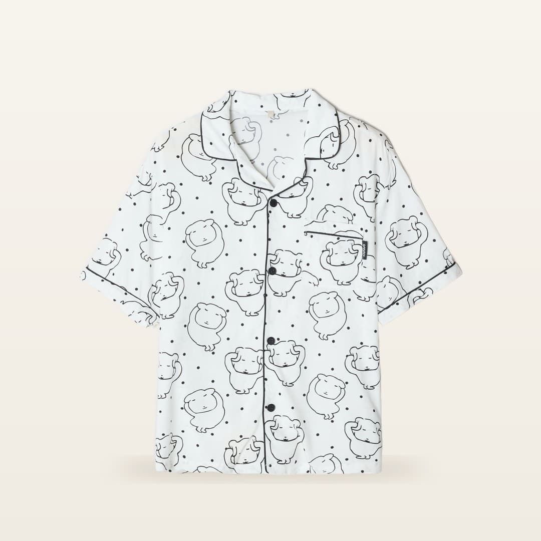 Ganadi short-sleeve pajama top, front flat lay — ivory with hand-drawn all-over character print